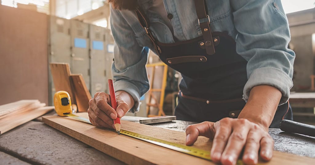Carpenter working with equipment on wooden table in carpentry shop. woman works in a carpentry shop.